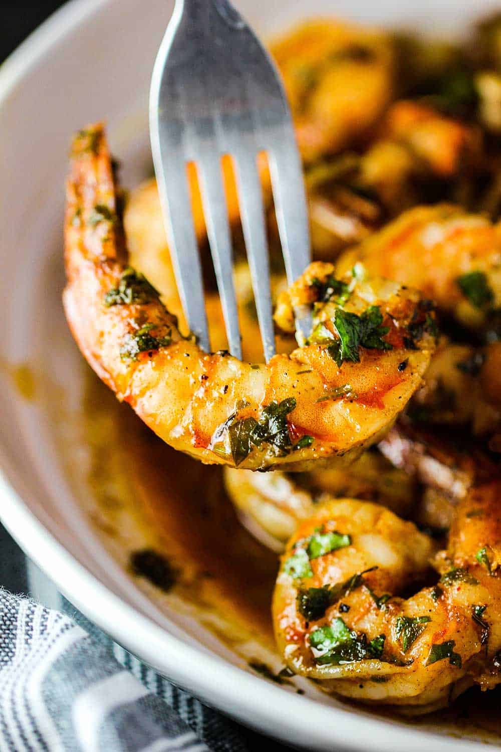 A fork holding a Cajun baked shrimp.
