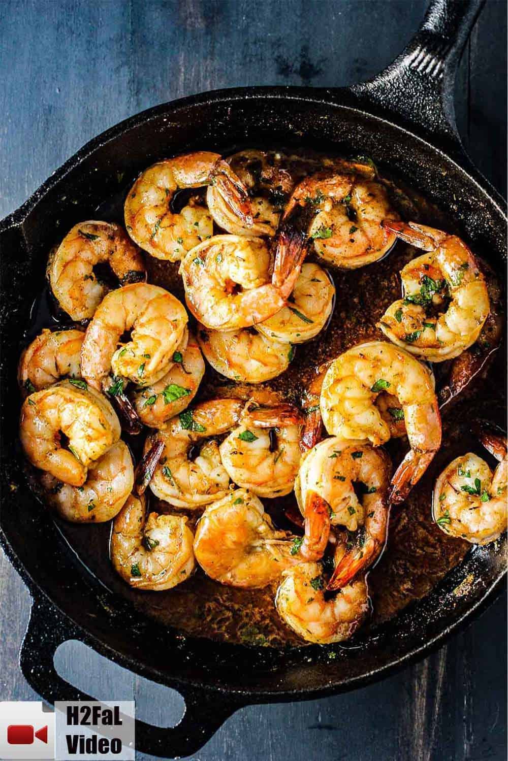 Baked cajun shrimp in a black cast iron skillet. 