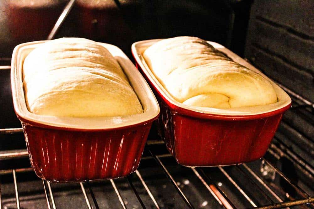 Homemade bread in two loaf pans in the oven