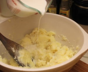 Pouring warm cream into potatoes...just wait for the cheese and chives!