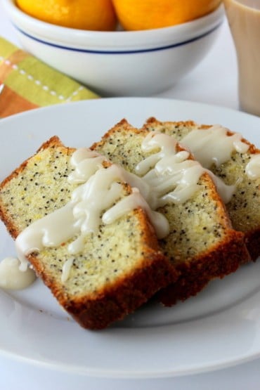 Incredible lemon poppy-seed pound cake on a white plate next to a patterned napkin and fork