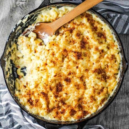 Ultimate Macaroni and Cheese in skillet with a wooden spoon.