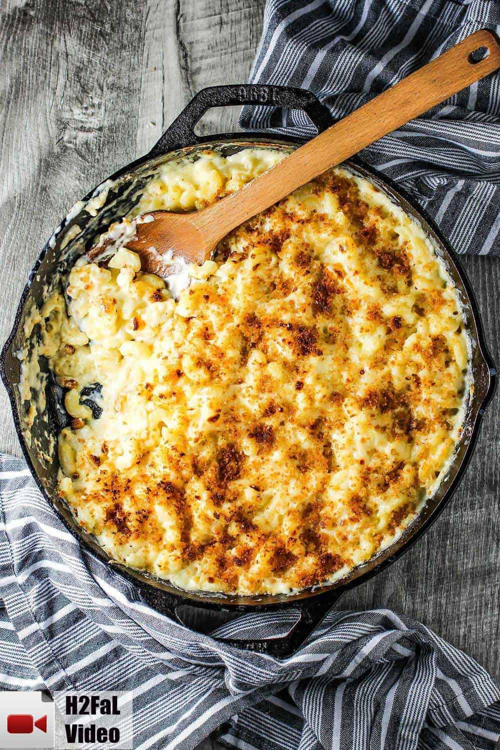 The Ultimate Macaroni and Cheese in a large cast iron skillet with a wooden spoon.