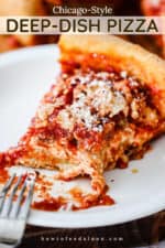 A slice of Chicago-style deep dish pizza on an individual plate with a bite taken out.