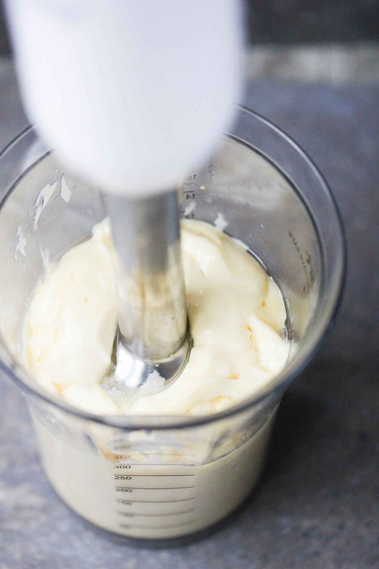 An immersion blender in a jar of homemade mayonnaise. 