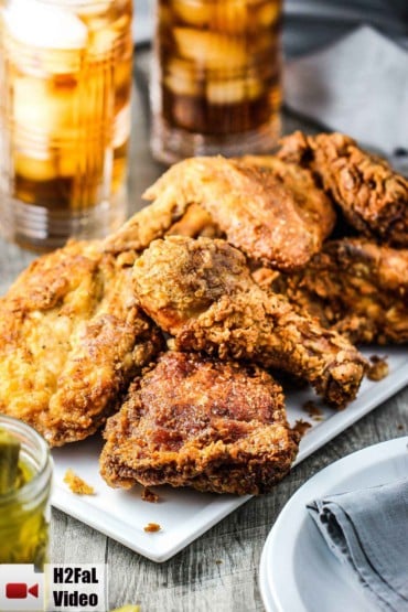 Southern Fried Chicken on a white platter with a glass of iced tea nearby