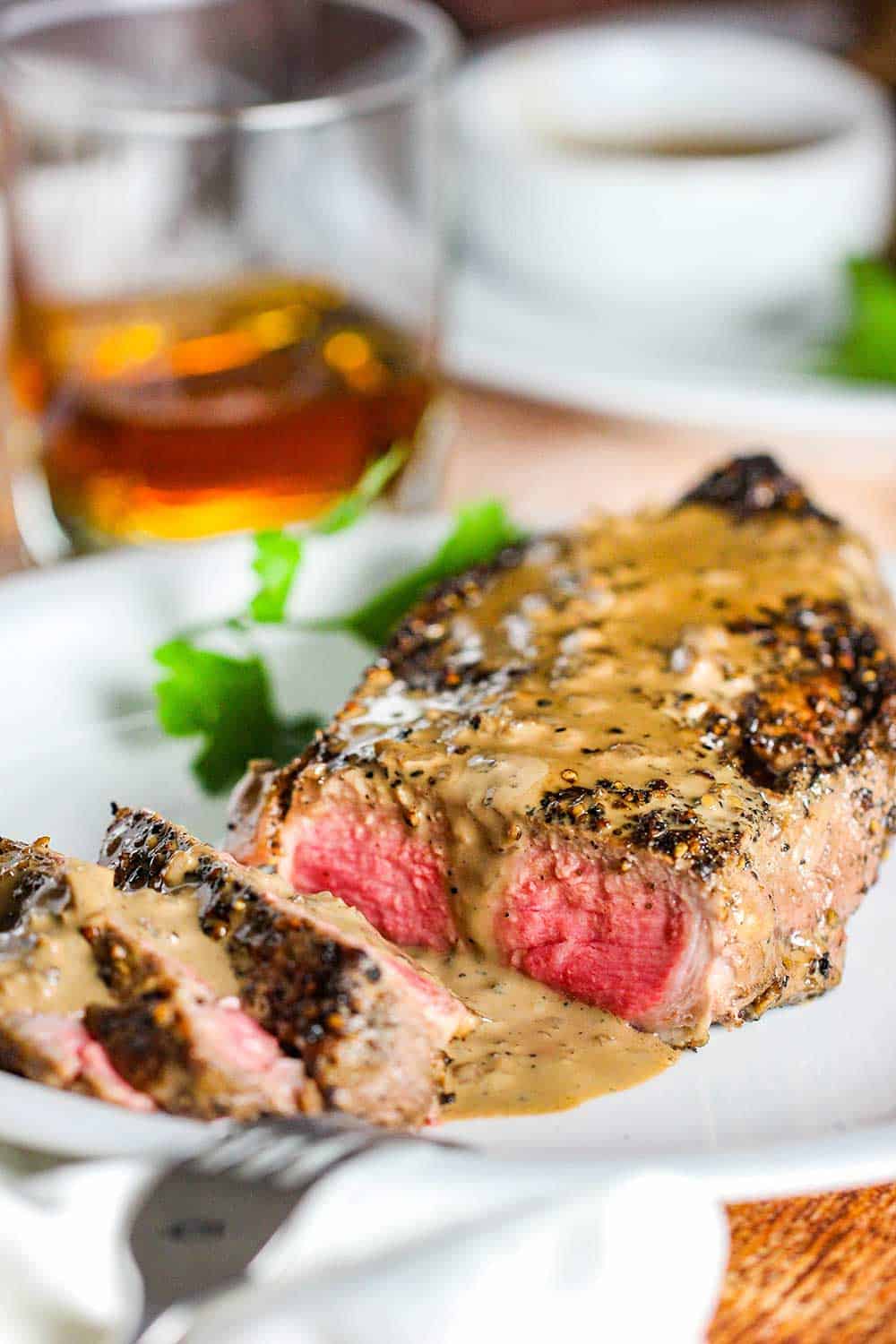 Slice the steak and then pour the au poivre sauce over the top and serve with a good brandy. 