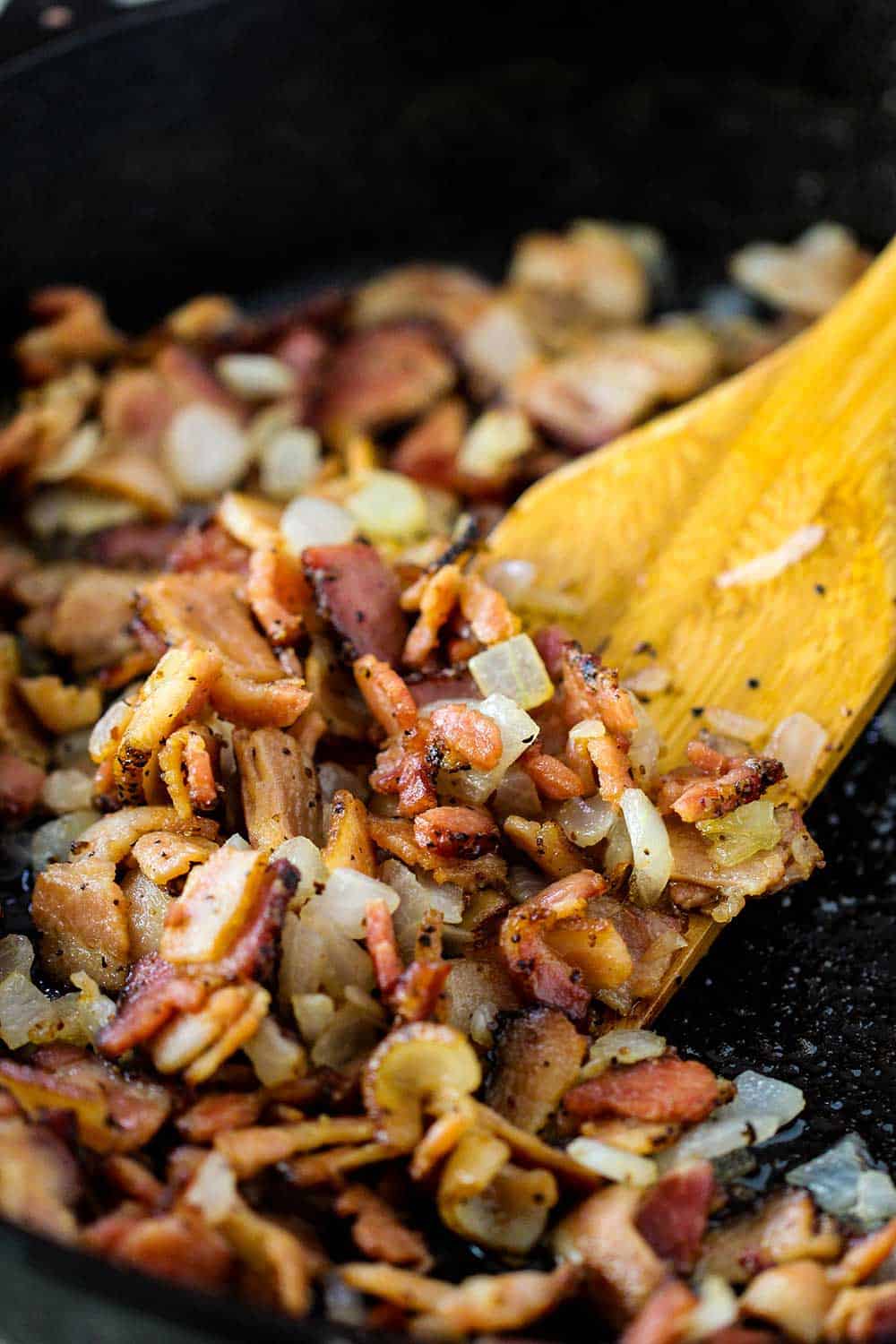 Cook smoked bacon and onion in a large skillet as a base for the baked beans. 