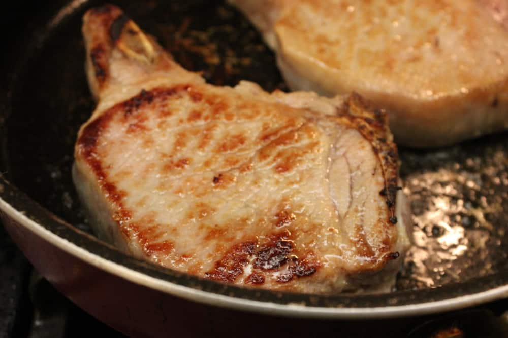 Chops browning beautifully in a hot skillet