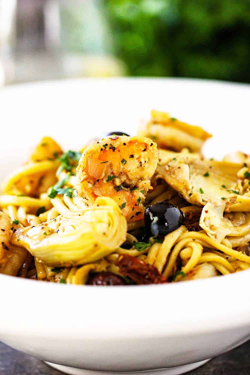 A close-up view of a bowl filled with Mediterranean pasta. 