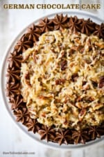 The top of a German chocolate cake covered with coconut pecan frosting and lined with chocolate frosting.