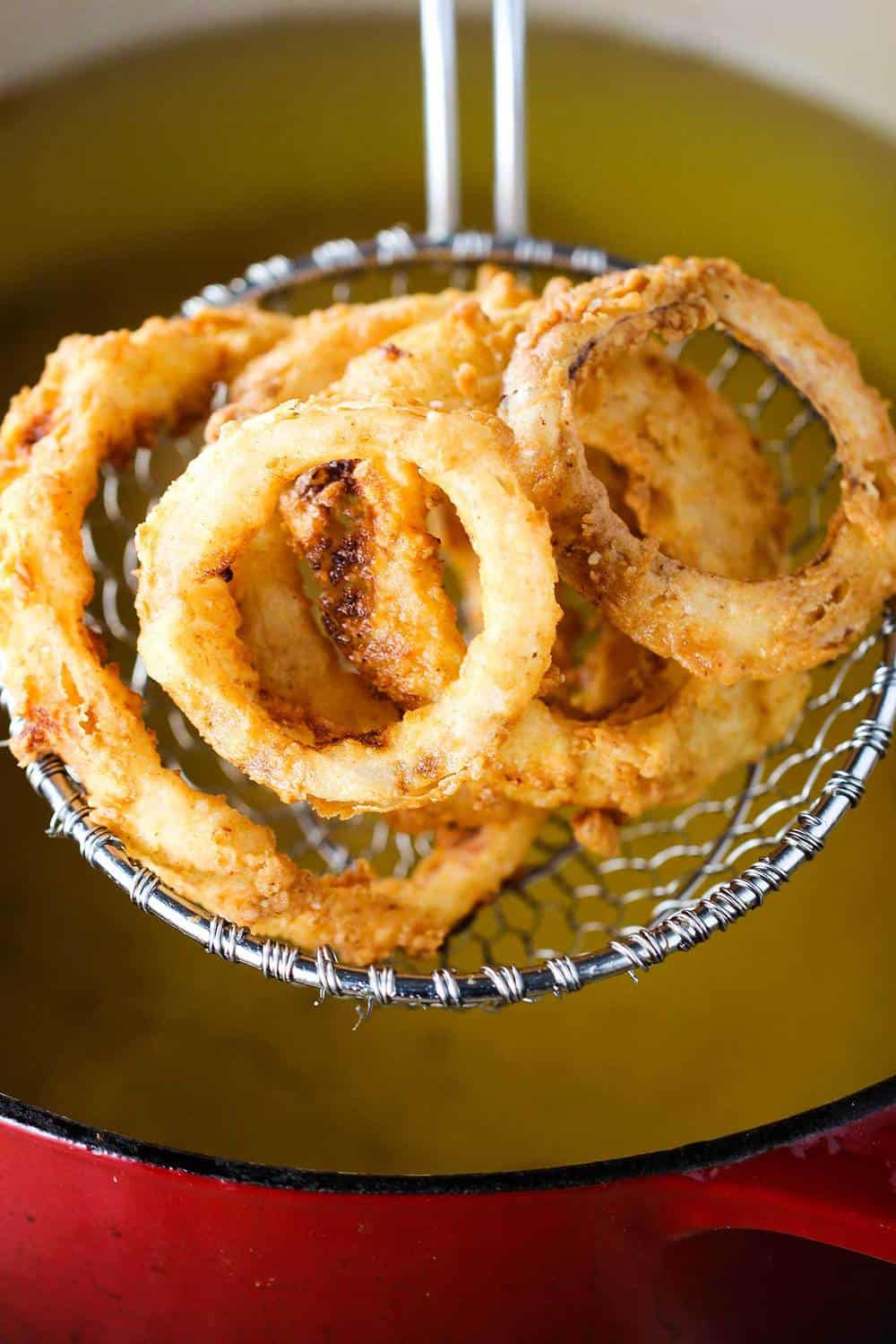 Onion rings being pulled from a deep fryer