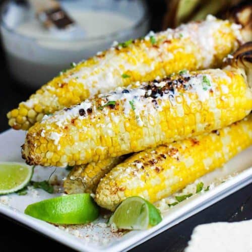 Mexican grilled corn with cream sauce on a white platter