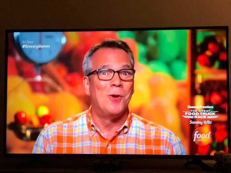 A shot of a TV with Kris talking about Chicken Fried Steak on Guy's Grocery Games. 