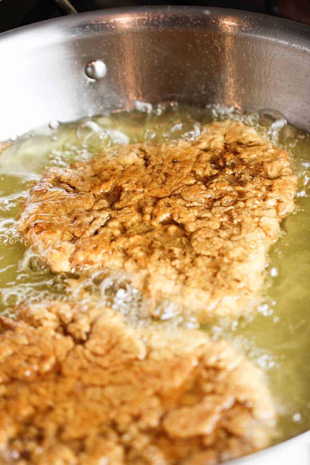 Fill a large skillet with just enough oil to partially submerge the steak as it fries. 