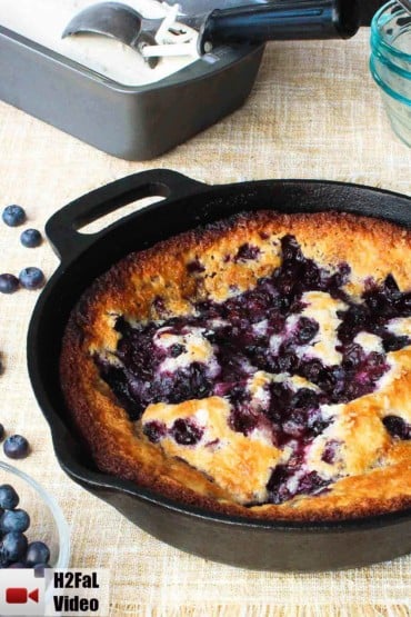 Lazy Day Blueberry Cobbler in a cast iron skillet next to blueberries