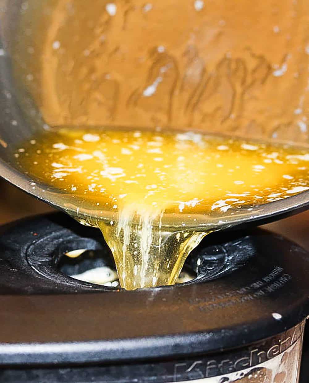 Butter being poured into blender for easy hollandaise sauce