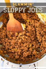 An overhead view of a skillet filled with sloppy joes meat mixture with a wooden spoon in the middle.