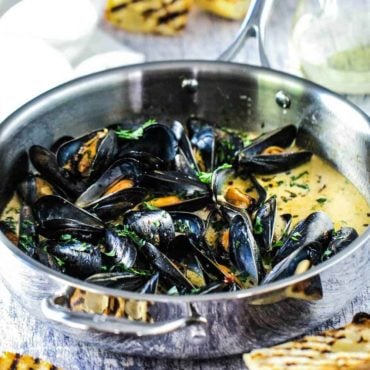 mussels with garlic and wine in a large silver saucepan.