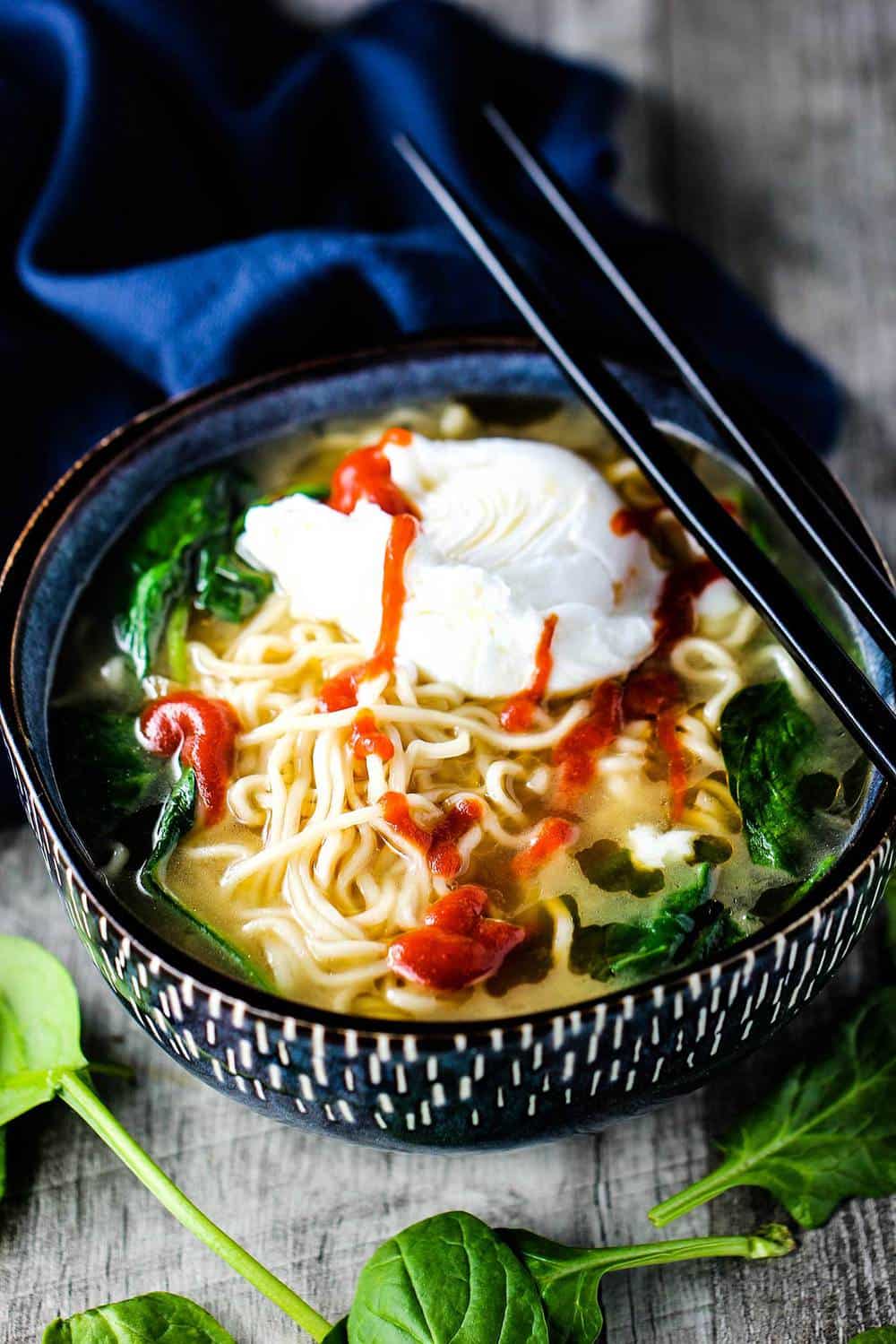 Spinach Ramen Soup with Poached Egg in a bowl with chop sticks on top