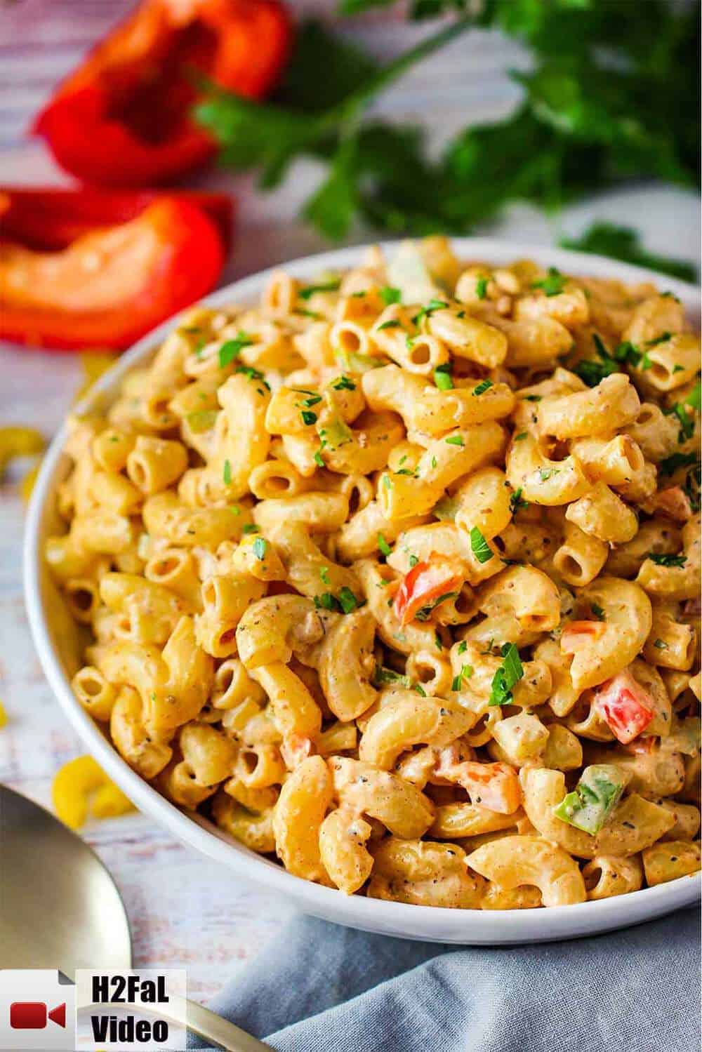 A large white bowl of freshly prepared Cajun Pasta Salad.