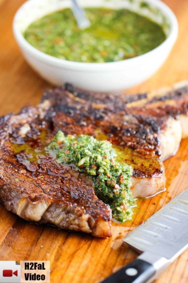 This is a grilled cowboy ribeye steak with chimichurri sauce on it