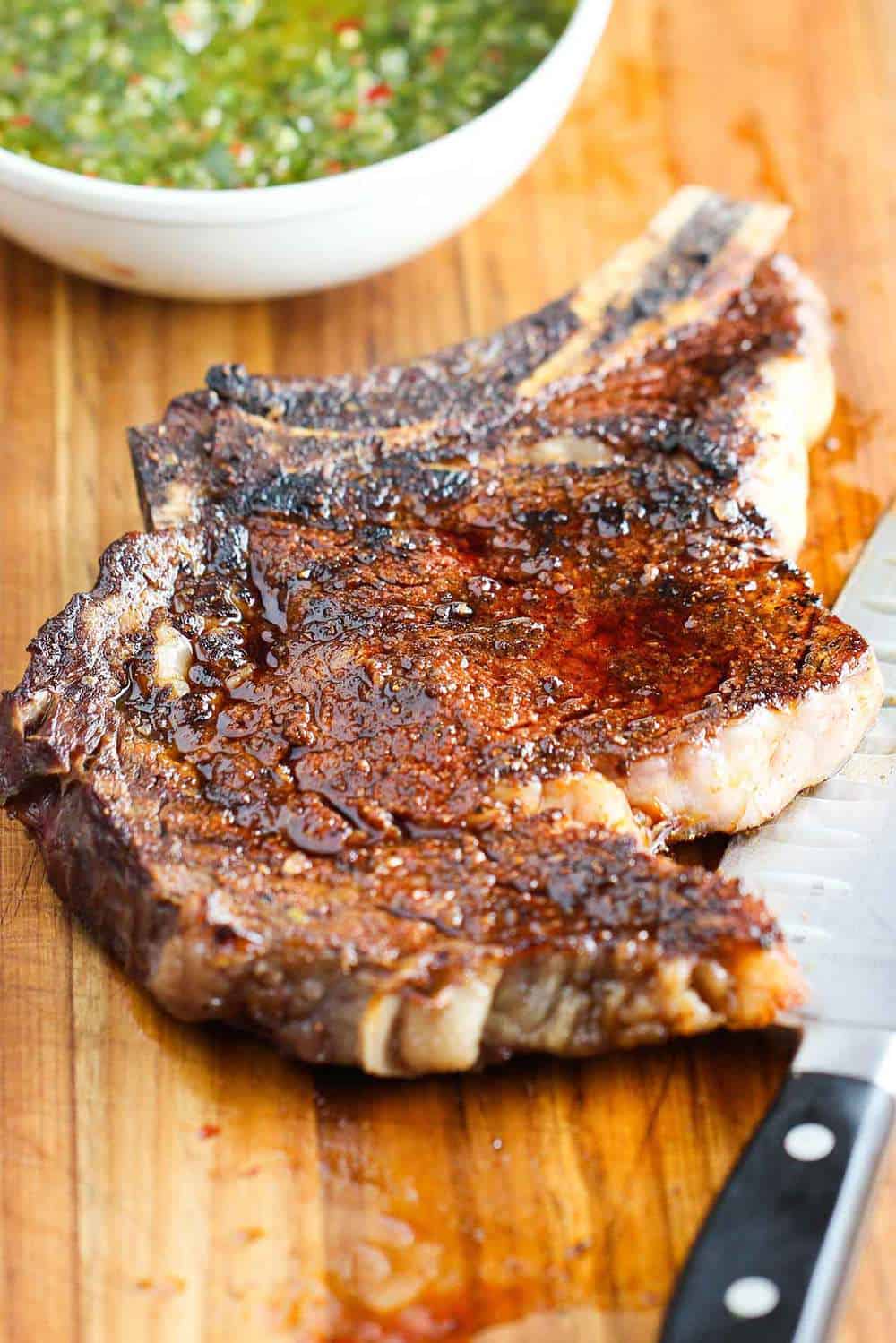 the grilled ribeye steak is resting on a cutting board
