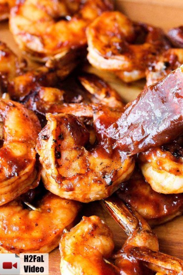 Grilled shrimp being brushed with homemade BBQ sauce