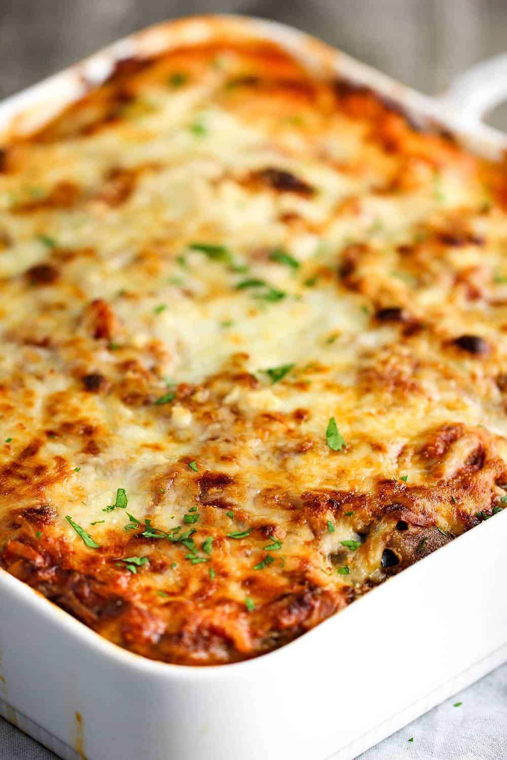 Authentic Eggplant Parmesan in a baking white dish.