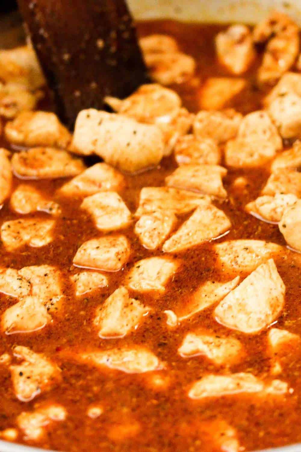 chicken pieces simmering in a Mexican sauce for chicken quesadillas