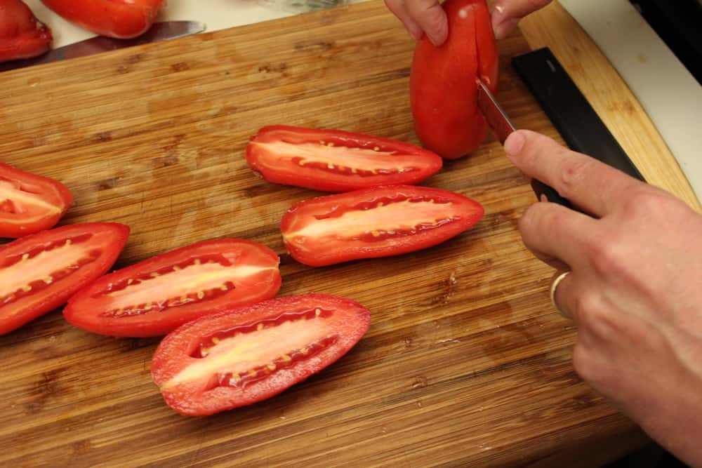 Slice the Roma tomatoes lengthwise, down the center