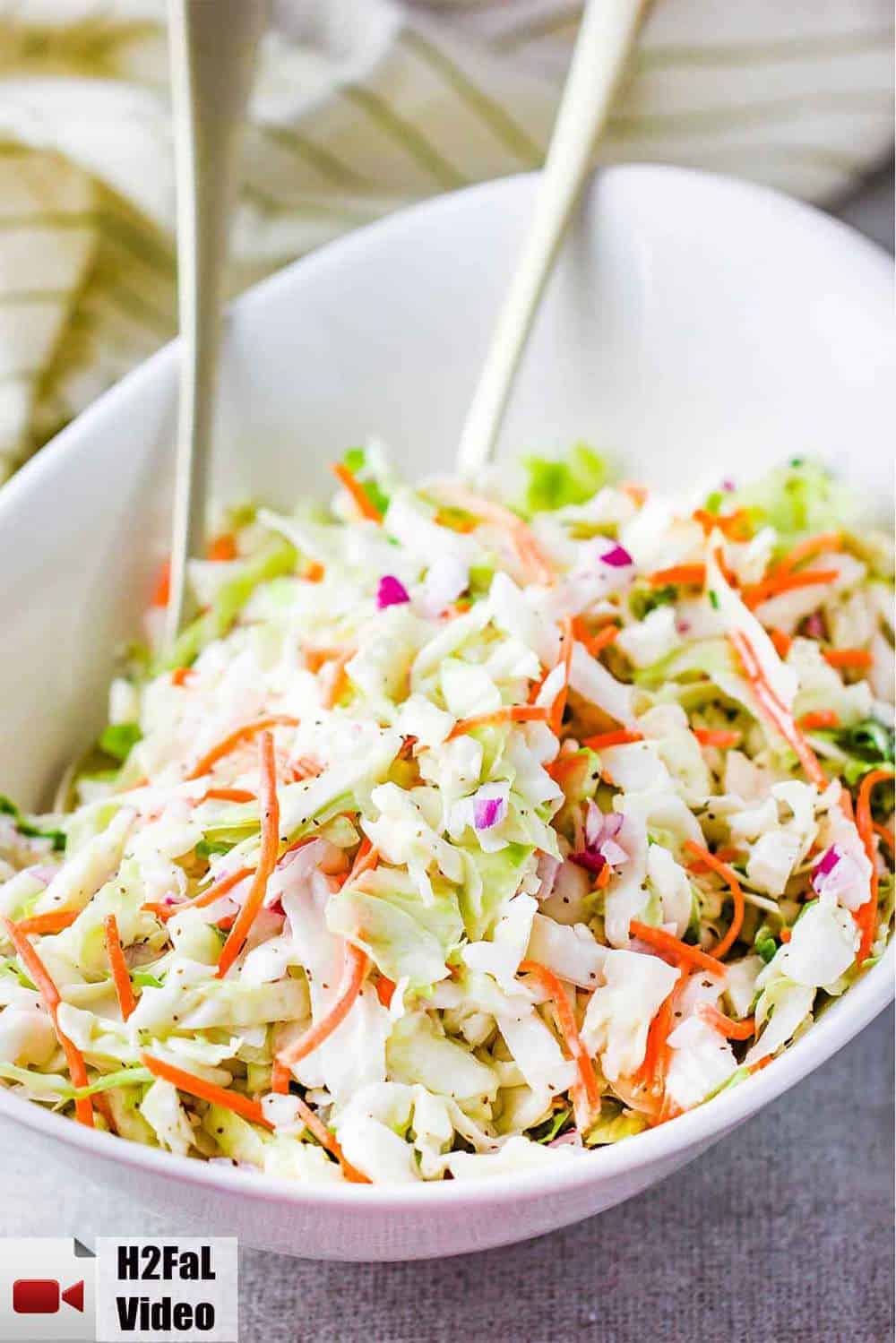 A large white bowl containing freshly made homemade coleslaw. 
