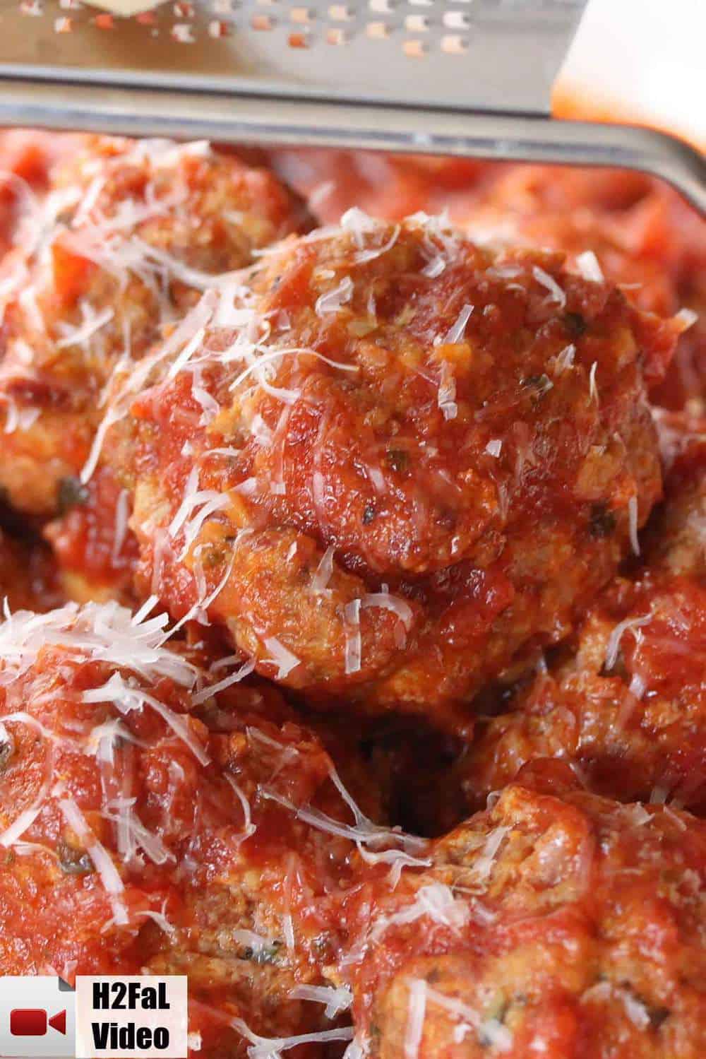 Close up of homemade Italian meatballs with Parmesan cheese on top.