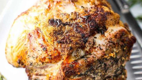 Slow Roasted Pork Shoulder on a platter with a side of gravy