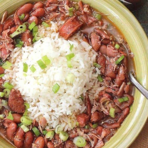 A green bowl holding red beans and rice with white rice in the center.