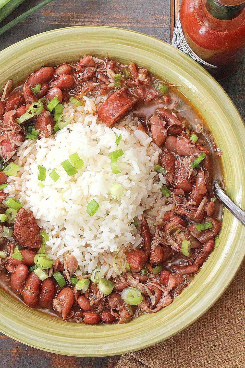 A green bowl holding red beans and rice with white rice in the center. 