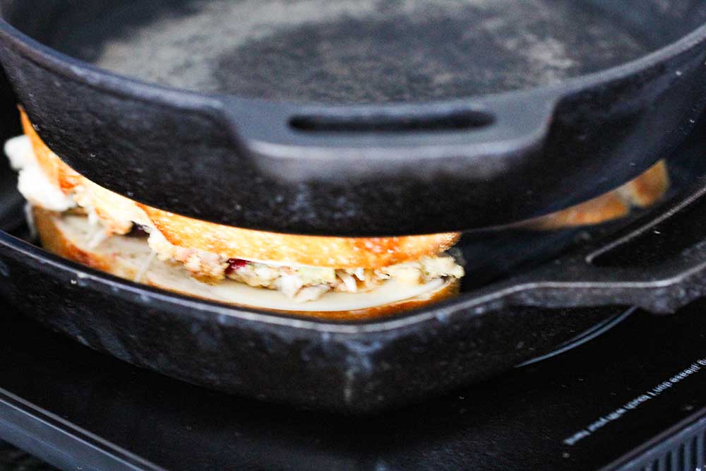 A cast iron skillet sitting on top of a panini in a grill skillet. 