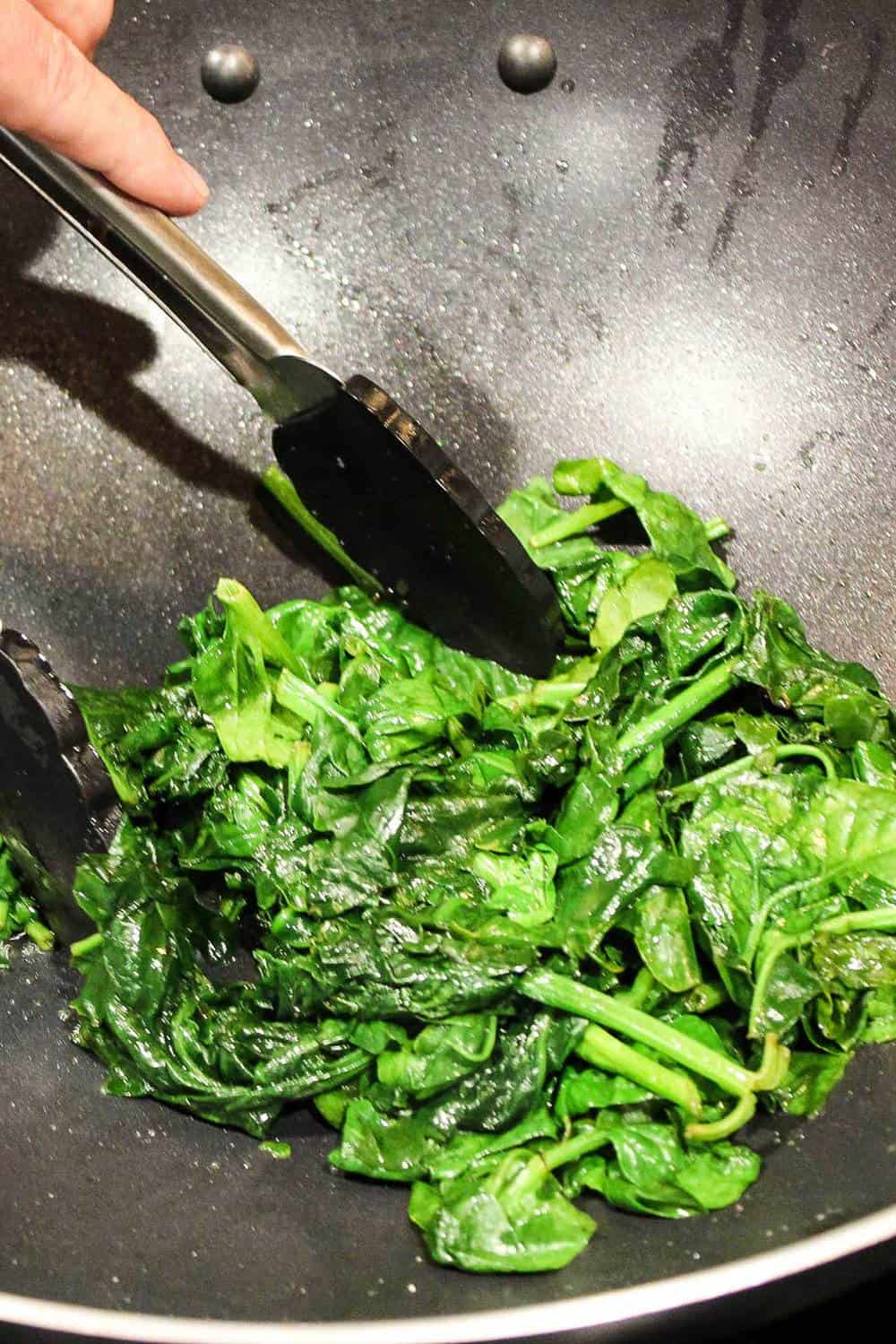 Sautéed spinach in a wok for authentic bibimbap