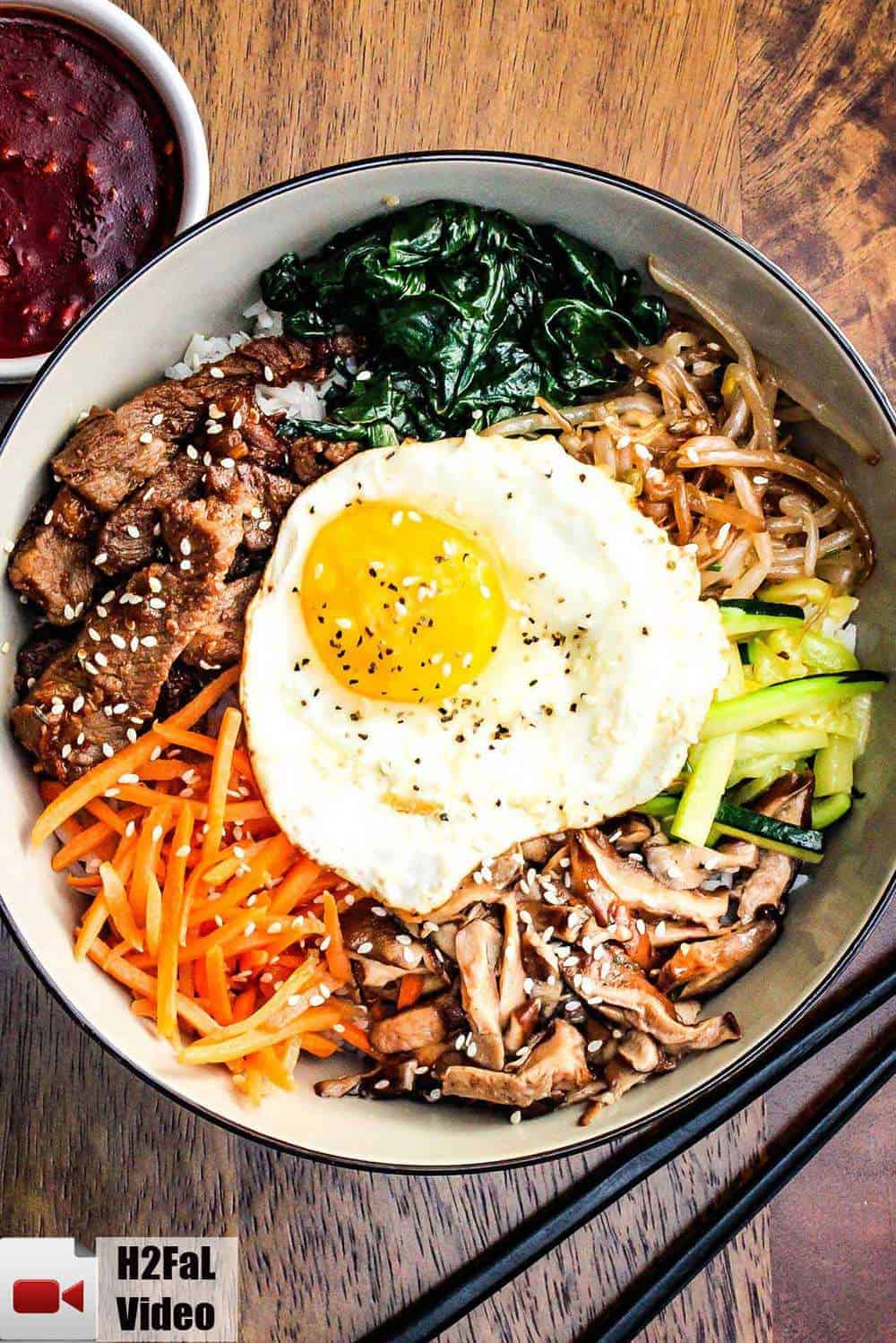 Authentic bibimbap in a bowl next to chop sticks