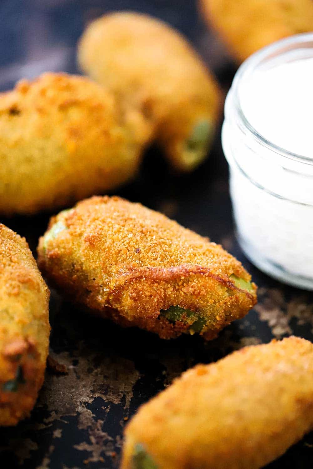 Stuffed Jalapeño poppers split open on a cutting board