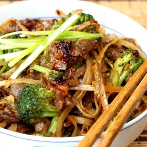 Beef & Broccoli Chow Fun in a white bowl with chopsticks