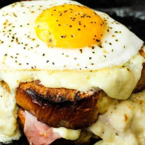 Croque Madame sandwich in a cast iron skillet with egg on top