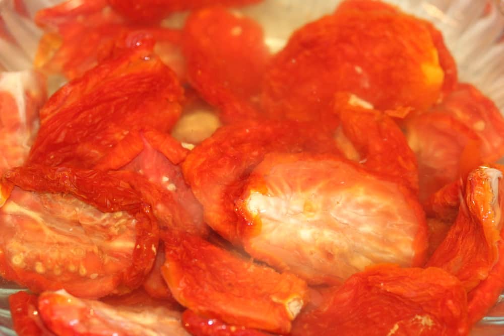 Re-hydrate the sun-dried tomatoes in a bowl of water
