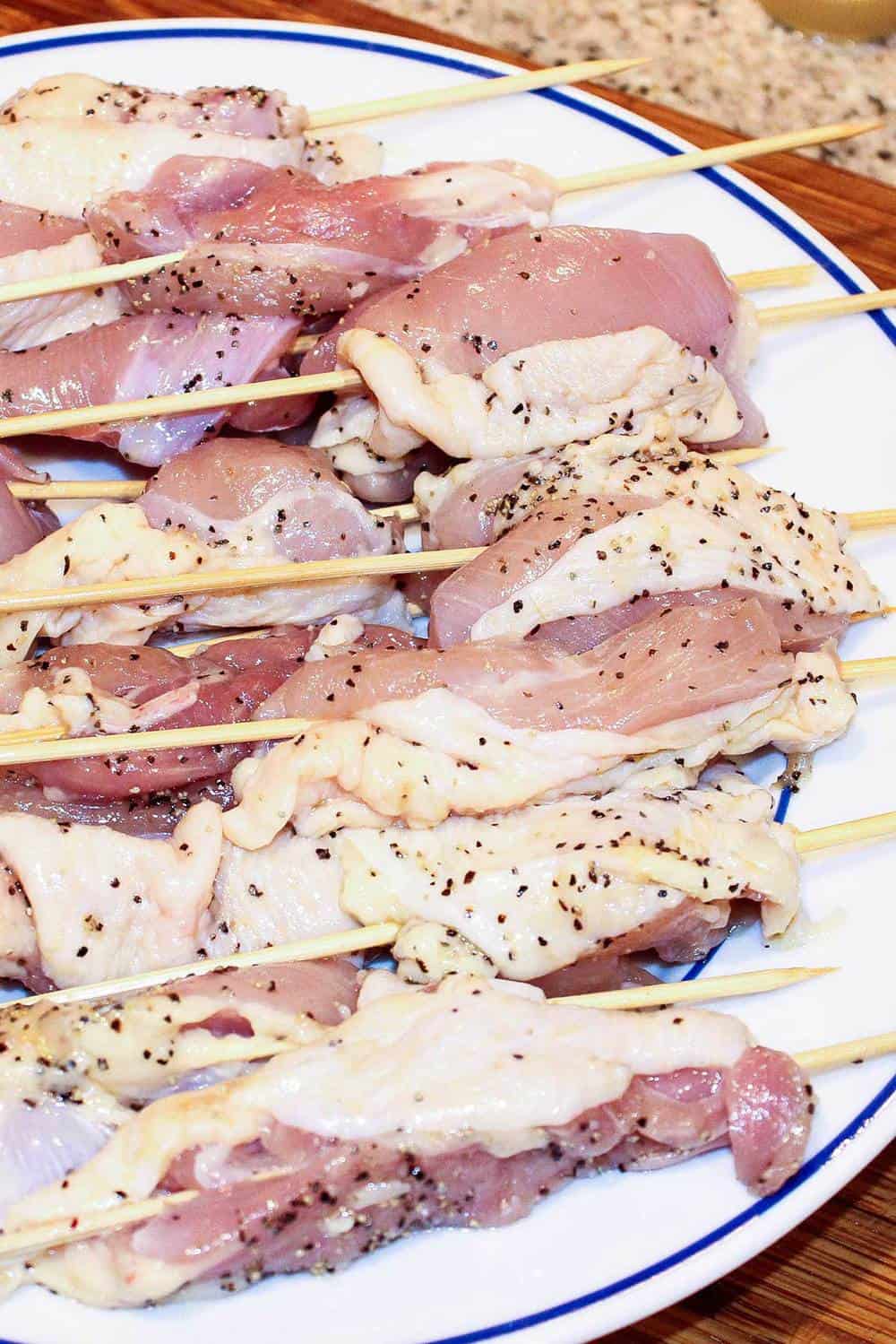 Raw chicken thigh meat on skewers ready for the grill. 