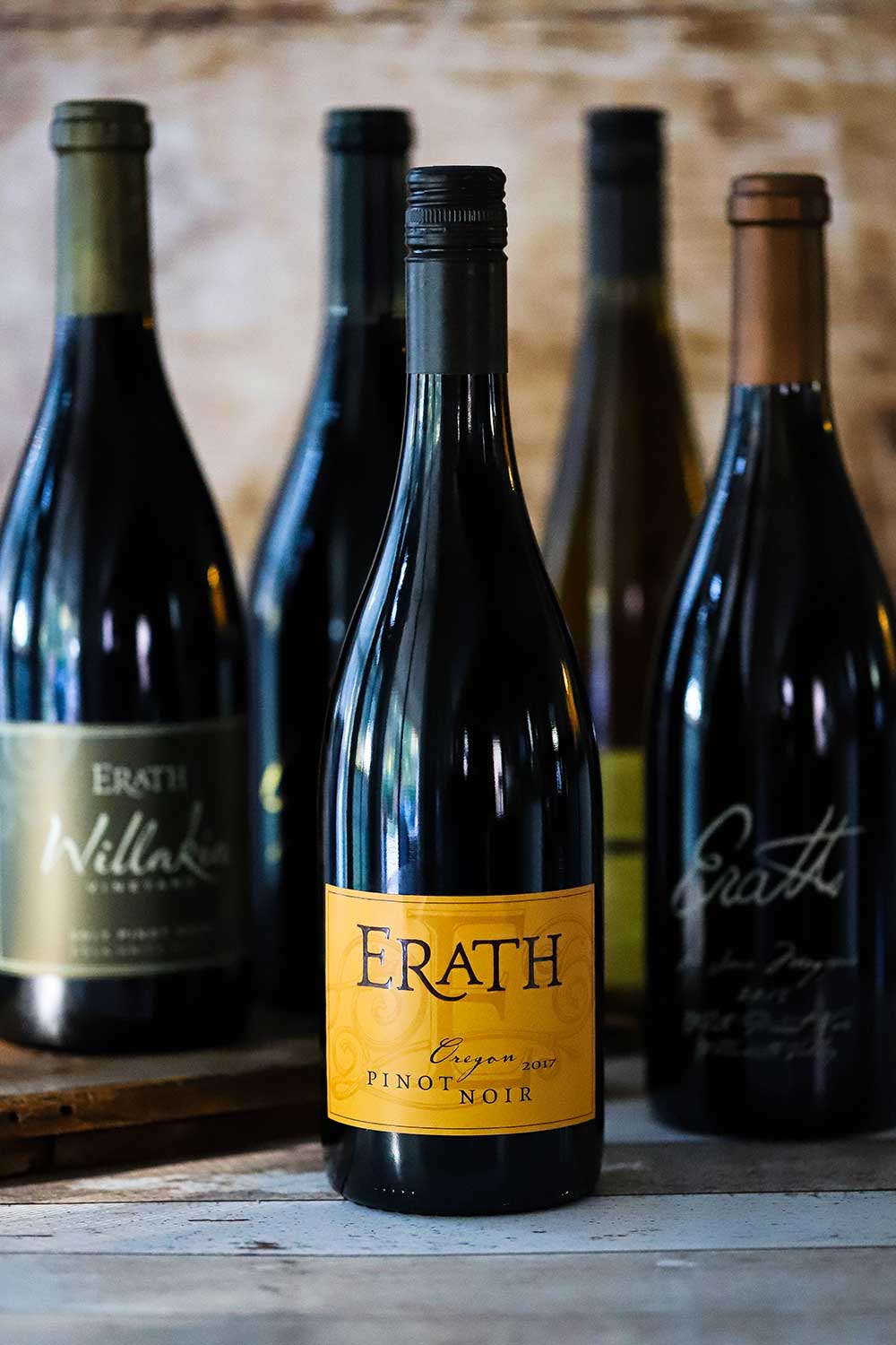 A collection of Erath Pinot Noir wine bottles standing next to each other. 