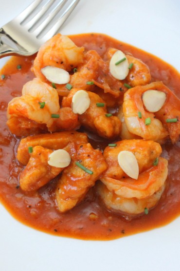 Pumpkin Gnocchi with Shrimp in a white bowl with a fork and knife