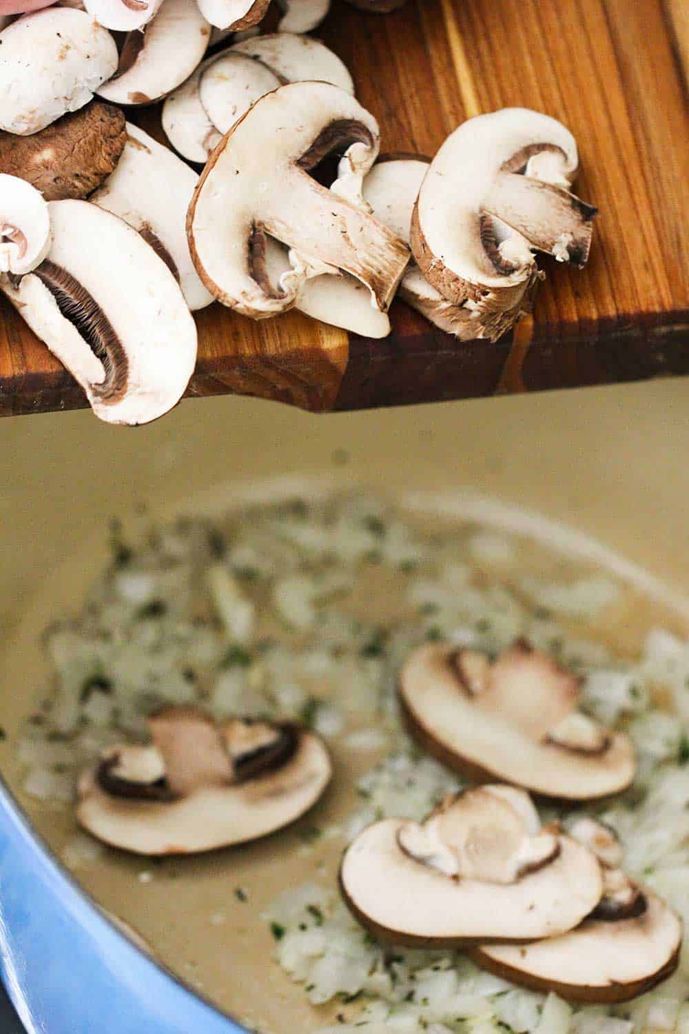 Sliced mushrooms being scraped off a cutting board into a Dutch oven of sautéed onions and garlic. 