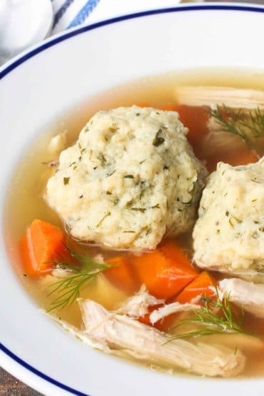 Matzo Ball Soup in a white with blue rim bowl