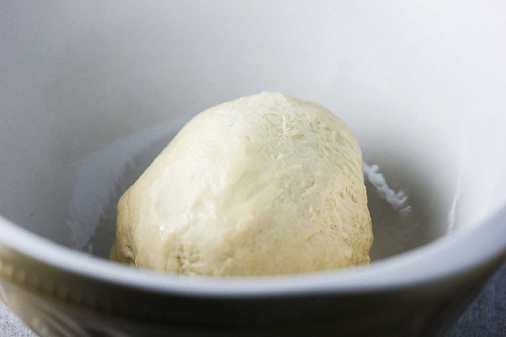 Doughnut dough in a large white bowl. 