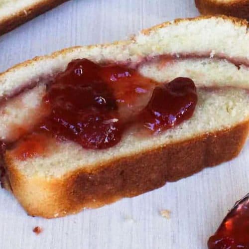 A slice of strawberry cream cheese pound cake topped with strawberry sauce